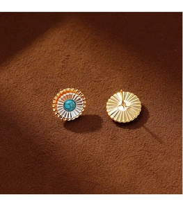 Vue macro des boucles d'oreilles fleur soleil avec turquoise et finition métal bicolore