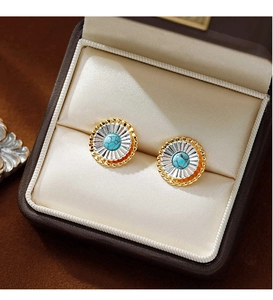 Vue macro détaillée des boucles d'oreilles fleurs bicolores avec incrustation de turquoise