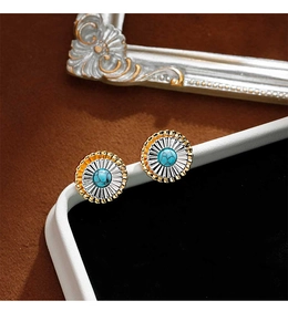 Détail des boucles d'oreilles fleurs bicolores avec pierres de turquoise centrales