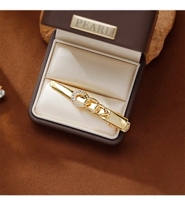 Detail of a gold chain hair clip with sparkling rhinestones in a velvet jewelry box