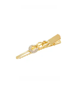 Macro detail of golden chain link hair clip with sparkling zircon circle inlay