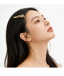 Close-up of golden chain-link hair clip with shimmering pavé rhinestones on model