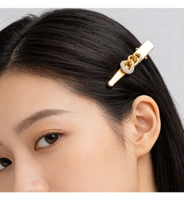 Close-up of golden chain hair clip with sparkling rhinestones worn on hair
