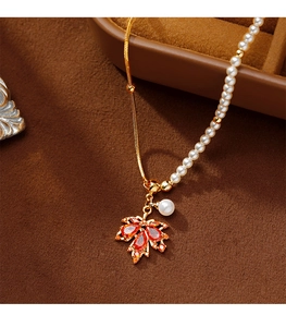 Détail du pendentif feuille d'érable rouge avec pierres orange et chaîne de perles