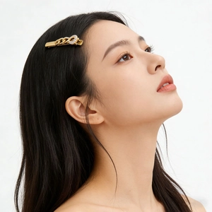 Elegant gold metal chain hair clip with sparkling rhinestones worn on black hair