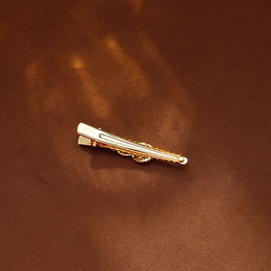 Minimalist gold chain link hair clip shown in an elegant top view on a velvet surface