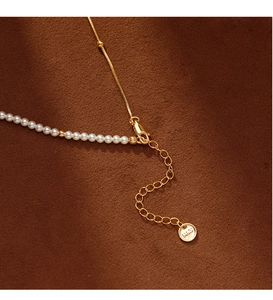 Détail du fermoir doré et des perles sur le collier pendentif feuille d'érable