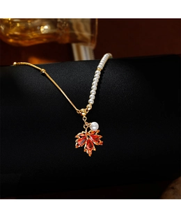 Détail du pendentif feuille d'érable rouge avec collier asymétrique perles et or