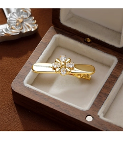 Macro d'une pince à cheveux fleur dorée avec pierres de zircon dans son coffret