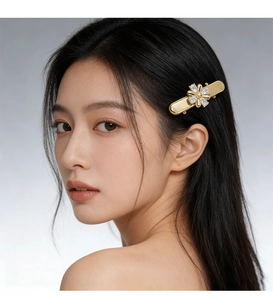Détail d'une pince à cheveux fleur dorée avec pierres de zircon sur un mannequin