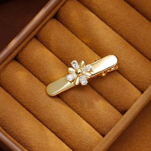 Barrette à cheveux fleur dorée avec cristaux de zircon sur une boîte à bijoux