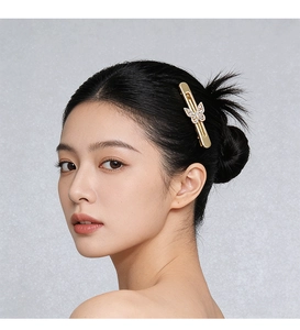 Vue détaillée de la pince à cheveux papillon dorée avec strass portée sur le côté