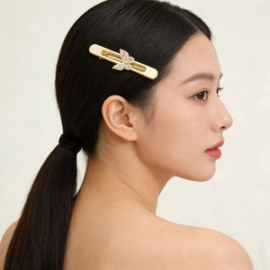 Barrette papillon dorée élégante avec zircons portée par une femme avec vue de profil