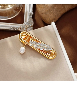 Detailed shot of golden feather hair clip with sparkling crystals and waterdrop pearl