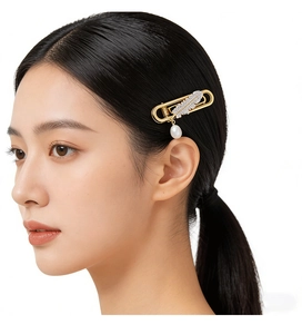 Detail of paperclip hair clip with rhinestone feather and pearl on black hair
