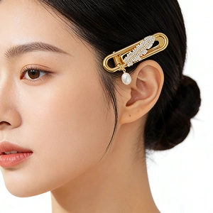 Golden feather hair clip with sparkling cubic zirconia and white pearl drop on model