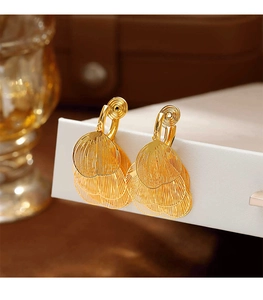 Detailed view of layered gold tassel earrings with intricate filigree texture for women