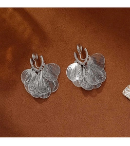Macro view of silver layered leaf clip-on earrings with vertical brushed texture