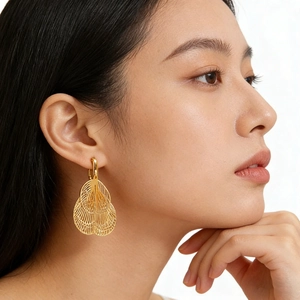 Elegant gold fringe leaf clip-on earrings with hollow mesh texture for unpierced ears