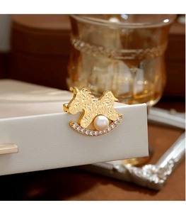 Détail de la broche cheval en or martelé avec perle blanche et oxydes de zirconium sertis