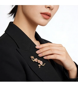 Vue détaillée d'une broche florale émaillée rose portée sur le revers d'un costume noir