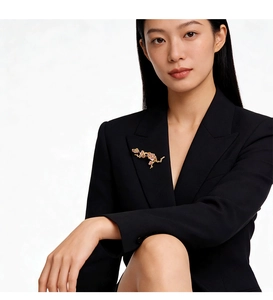 Détail d'une broche florale en émail épinglée sur le revers d'un blazer noir cintré