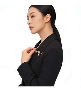 Détail d'une luxueuse broche fleur en émail épinglée sur un blazer noir femme