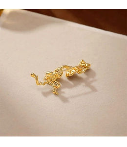Détail d'une broche branche de prunier dorée avec une finition en émail de luxe