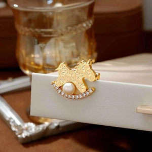 Broche cheval à bascule doré avec perle et oxydes de zirconium sur présentoir