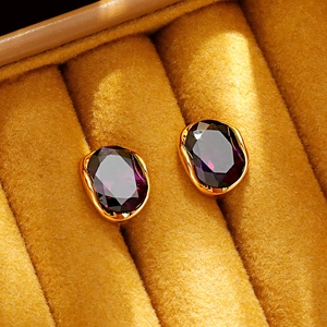 Elegant gold oval earrings featuring sparkling purple zircons in a yellow velvet box