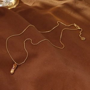 Collana dorata con ciondolo a scarpa sportiva e strass rosa su velluto scuro