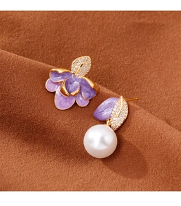 Détails de boucles d'oreilles asymétriques en émail violet avec fleurs et perles