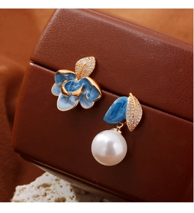 Macro d'oreilles asymétriques en émail bleu avec perles sur coffret cuir