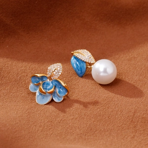 Boucles d'oreilles asymétriques en émail bleu avec feuilles dorées et perle blanche
