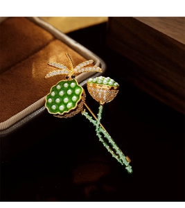 Makroaufnahme der eleganten Lotus- und Libellen-Brosche mit grünem Emaille und Perlen