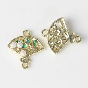 Detail of fan-shaped jewelry connector with white pearls and green enamel leaf work
