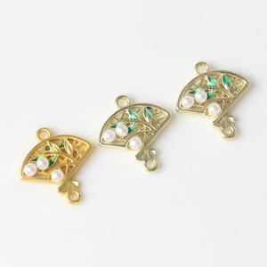 Detail of fan-shaped alloy pendants with green enamel leaves and white pearls for DIY jewelry