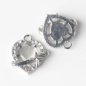 Close-up of heart charm with white cat eye stone and sparkling star element detail