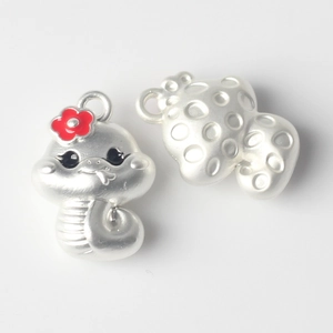 Detail of silver cartoon dragon pendant with red flower and textured back surface