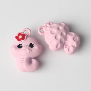 Macro detail of cute pink dragon charms with floral patterns for DIY jewelry making