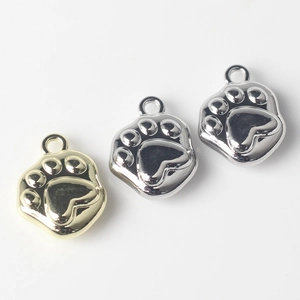 Detalle de colgantes de huella de gato en aleación pulida para creación de joyas artesanal