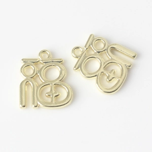 Close-up of golden Fu character charms with loop rings for DIY jewelry making