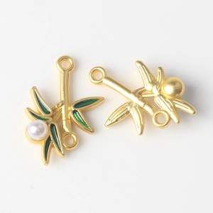 Detailed view of bamboo leaf alloy pendants with green enamel and white pearls for DIY jewelry