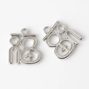 Close-up of silver hollow Fu character pendant charms for DIY jewelry making
