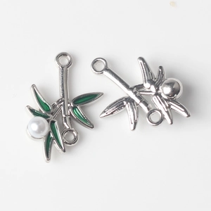 Detailed view of bamboo leaf pendants with green enamel and pearls for DIY jewelry