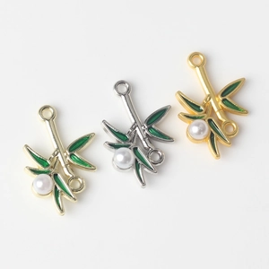 Detail of green enamel bamboo leaf pendants with pearls for DIY jewelry making