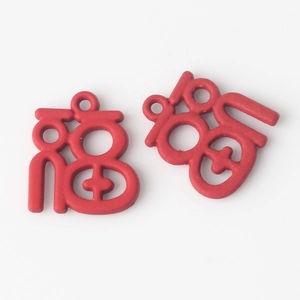 Close-up of red hollowed-out Fu character charms for DIY jewelry and festive decor