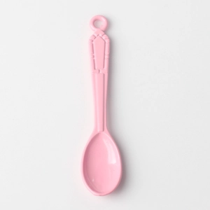 Macro detail of pink alloy spoon pendant with vintage embossed pattern and hanging hole