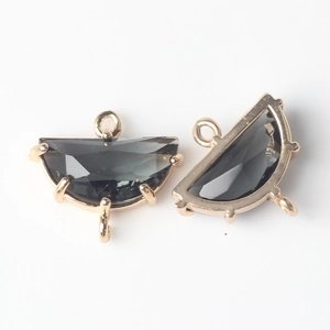 Detailed view of half-moon dark gray faceted stone pendants with three gold-plated loops