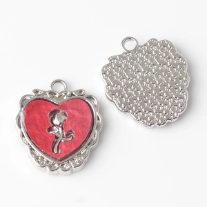 Detail of red resin heart pendants with silver rose relief and star texture backing